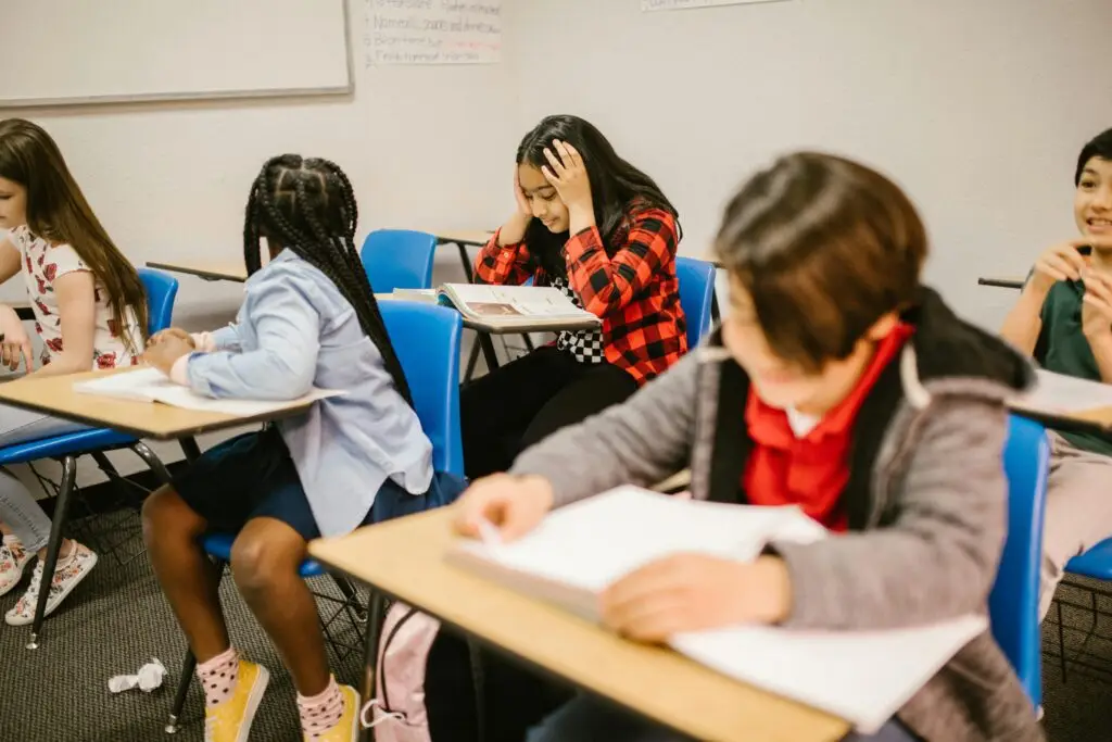 Diverse group of students engaged in study session inside a classroom setting.